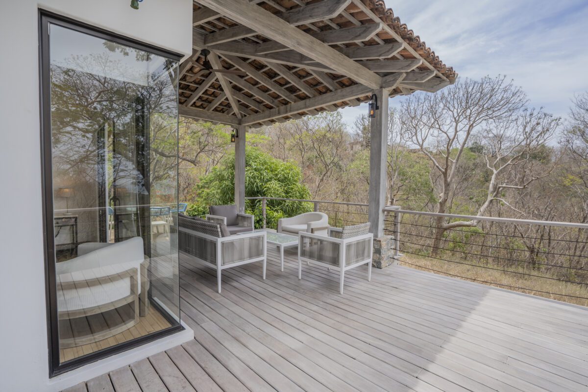 http://Una%20espaciosa%20terraza%20de%20madera%20con%20modernos%20muebles%20de%20exterior%20blancos%20ofrece%20vistas%20a%20una%20zona%20boscosa.%20La%20terraza%20cuenta%20con%20un%20techo%20de%20madera%20con%20vigas%20a%20la%20vista%20y%20barandillas%20metálicas,%20creando%20una%20relajante%20zona%20de%20estar%20al%20aire%20libre.