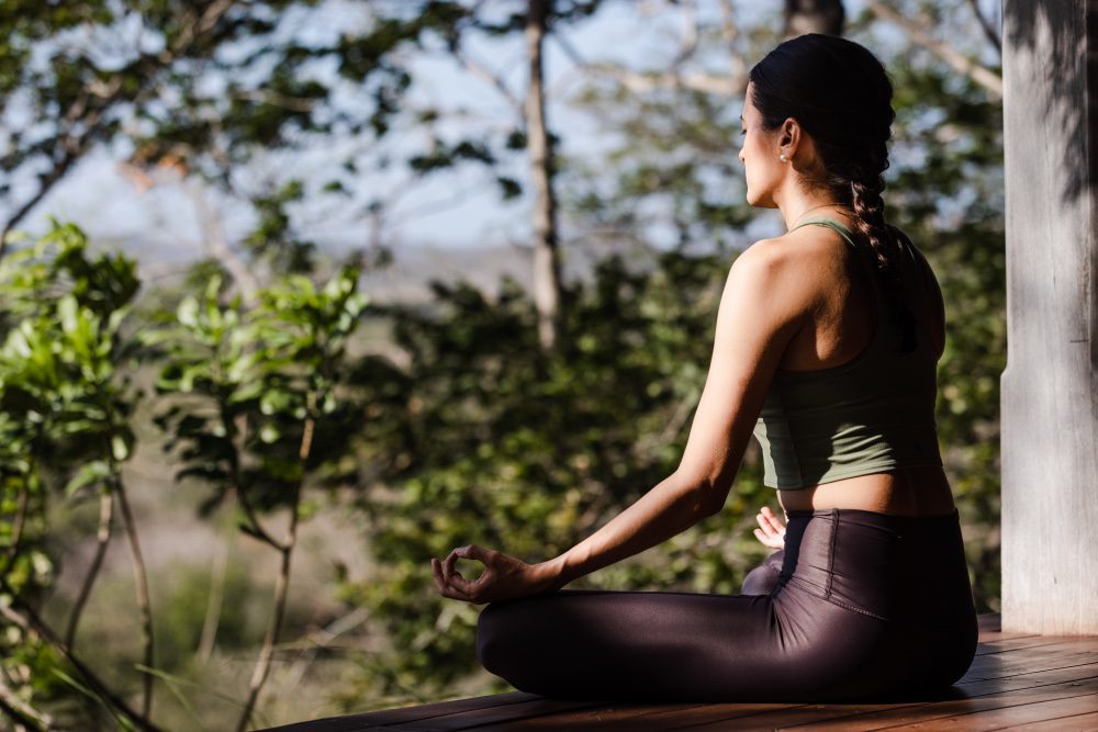 wellness traveler doing yoga in blue and green spaces at Rancho Santana resort