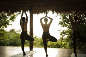 view of 3 women doing yoga at Rancho Santana Beach Resort