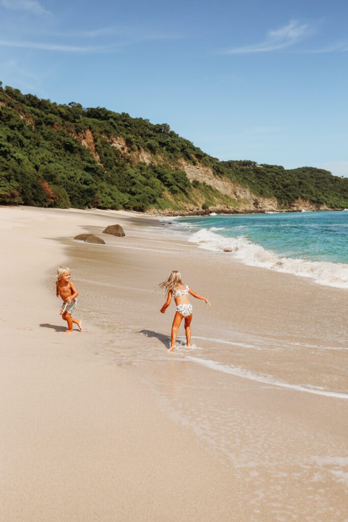 view of kids running on Playa Escondida, Rancho Santana beach